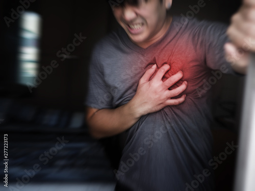 Severe heartache, man suffering from chest pain, having heart attack or painful cramps, pressing on chest with painful expression