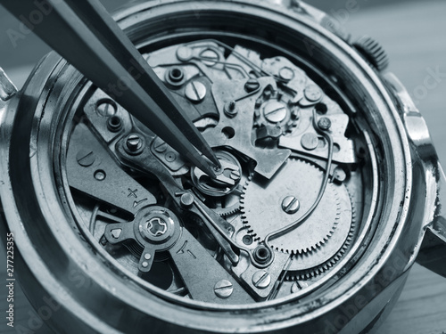 close up macro pic of watchmaker repairing vintage chronograph watch mechanism