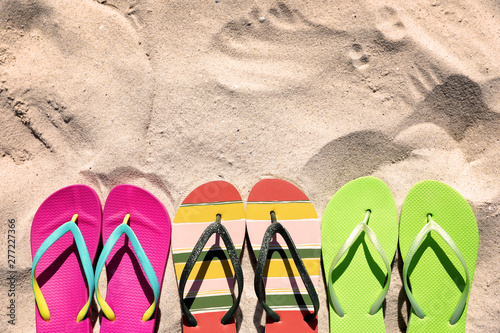 Flat lay composition with flip flops on sand in summer  space for text. Beach accessories