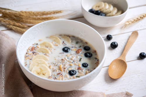 Bowl of granola almond and grains with blueberry and banana on wooden table, Healthy breakfast photo