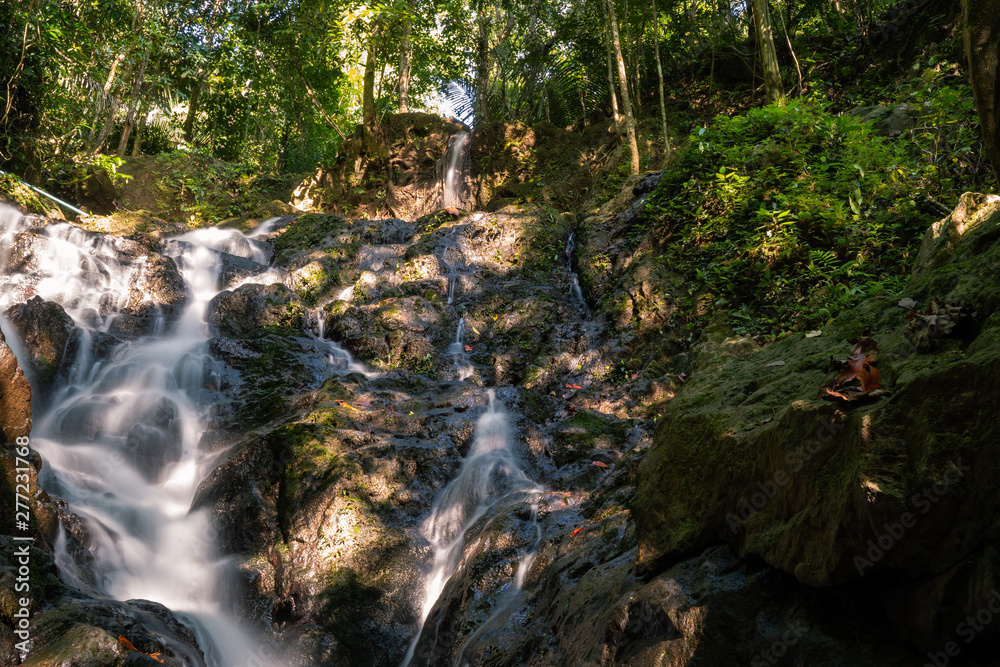 Obraz premium Ton Sai Waterfall in the tropical forest area In Asia, suitable for walks, nature walks and hiking, adventure photography Of the national park Phuket Thailand.