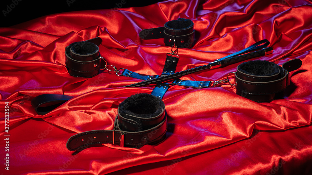 Foto Stock Top view of bdsm outfit. Bondage and spank on the red linen.  Adult sex games. Kinky lifestyle. | Adobe Stock