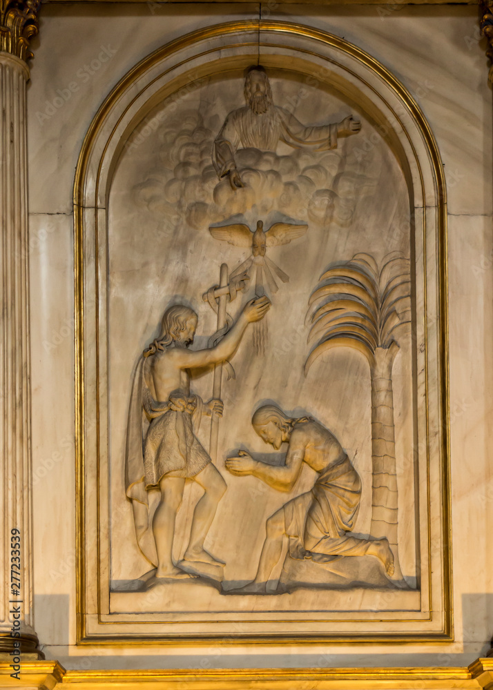 Turin, Italy, June 27, 2019: Bas-relief depicting the baptism of Jesus on the wall in Cathedral of Saint John the Baptist (Duomo) of Turin