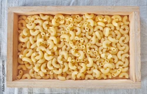 Photos Dried Elbow Macaroni in A Wooden Tray