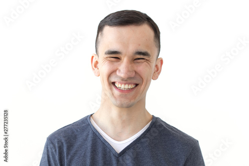 Expression and gesture concept - Portrait of laughing asian man on white background