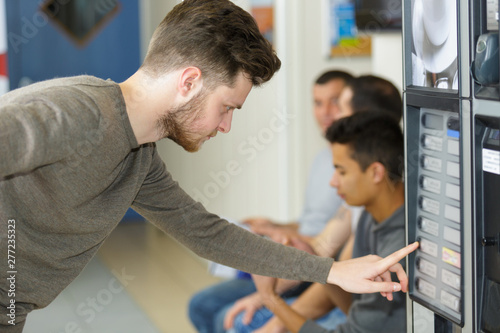 man inserting euro coin to vending machine money slot