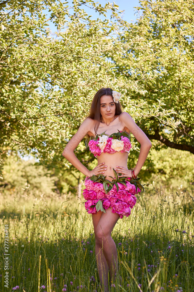Beautiful young girl in the apple garden, open clothes from fresh flowers of peonies. Beautiful young girl in the apple garden, open clothes from fresh flowers of peonies.