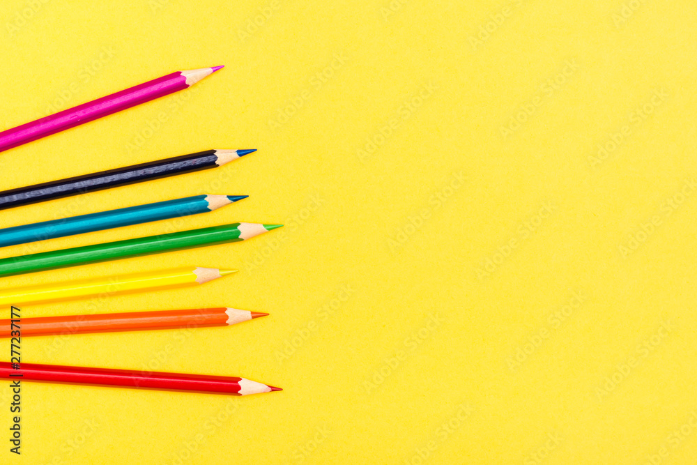 Colored wooden pencils on a yellow background. Rainbow palette. Copy space Colored wooden pencils on a yellow background. Rainbow palette. Copy space