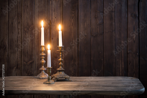 burning candle on old wooden background