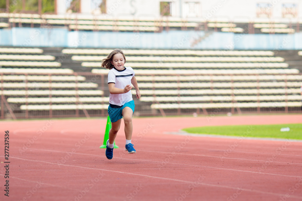 Child running in stadium. Kids run. Healthy sport.