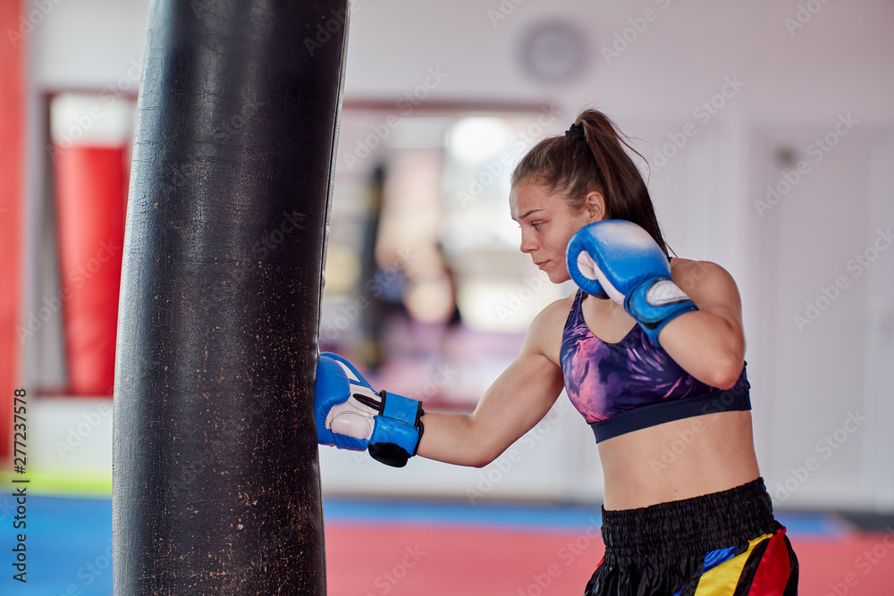 Boxer girl hitting the heavy bag