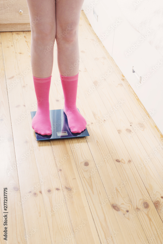 female feet in socks on the floor scales