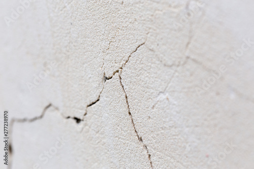 closeup background of cracked light porple plaster wall with selective focus and naturla blur photo