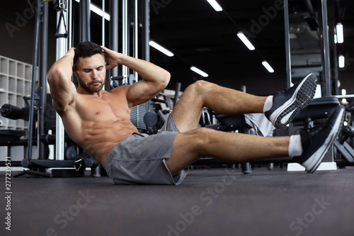 Sporty man stretching and warm-up doing special exercises for muscles before work his body out.
