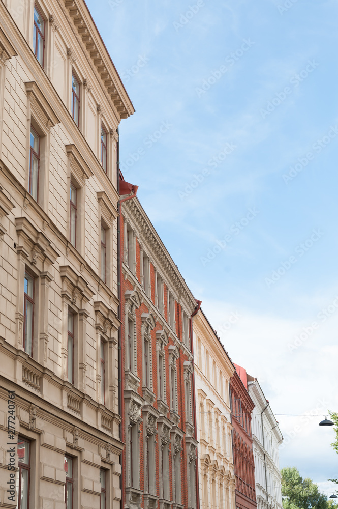 Multi storey beige and white stone apartment houses in a town street.