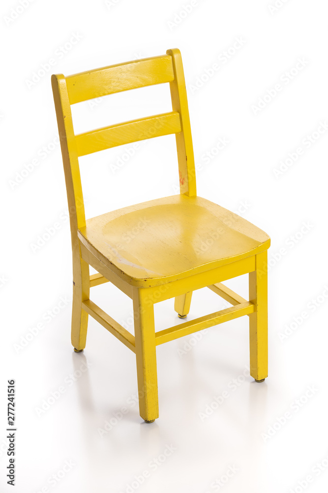 Wooden child chair painted yellow isolated on a white background. Wooden child chair painted yellow isolated on a white background.