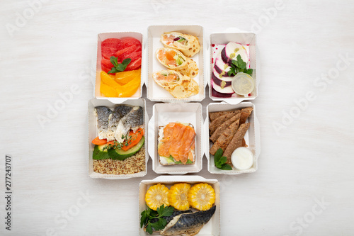Set of healthy meals for the day in lunch boxes stands on a white table. Concept of menu of proper nutrition is the balance of proteins, fats and carbohydrates