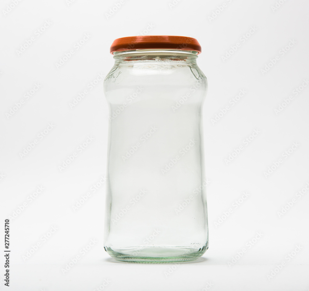 Empty glass jar with an orange lid on white background. Empty glass jar with an orange lid on white background.