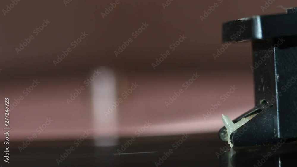 Vinyl record spins on the player. The head of the player is lowered. The needle is on the track. Everything is covered with dust Vinyl record spins on the player. The head of the player is lowered. The needle is on the track. Everything is covered with dust