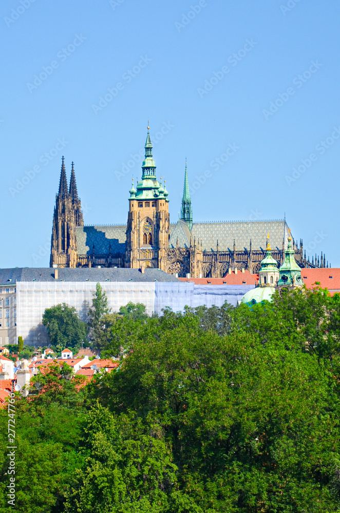 Beautiful Prague Castle with St. Vitus Cathedral, Bohemia, Czech Republic surrounded by historical old town and green trees. Hradcany, Praga, Czechia. European cities