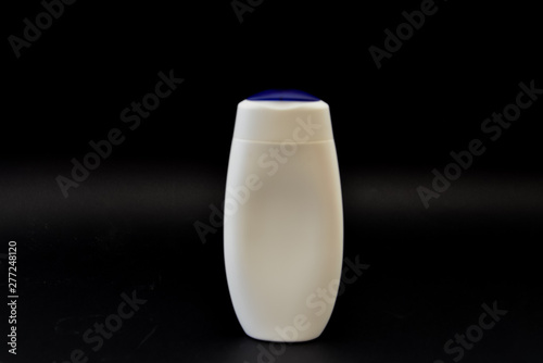 A bottle of household chemicals cosmetics on a black background neck of a bottle close up macro pattern