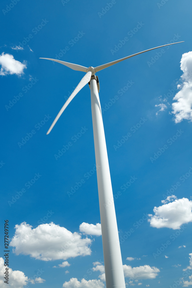 Electricity wind generator on bright cloudy sky background - wind energy and technology concept Electricity wind generator on bright cloudy sky background - wind energy and technology concept