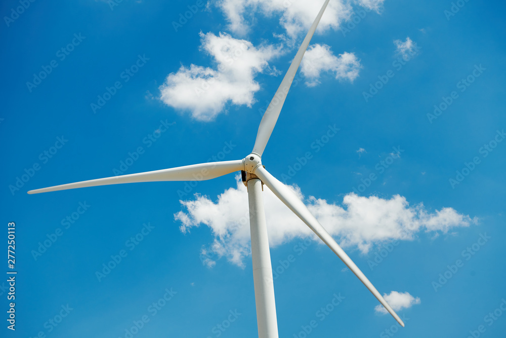 Electricity wind generator on bright cloudy sky background - wind energy and technology concept Electricity wind generator on bright cloudy sky background - wind energy and technology concept