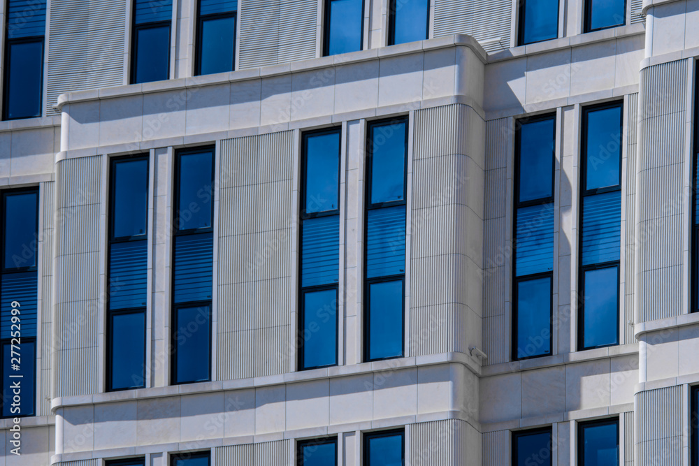 Obraz premium Part of modern office building with blue windows closeup. European architecture example