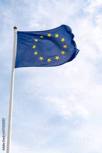 waving flag of European Union in cloudy sky in mat