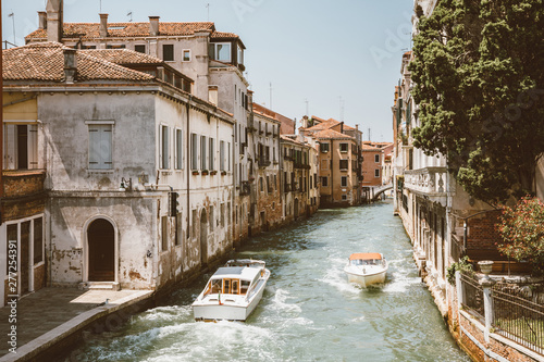 Panoramic view of Venice narrow canal with historical buildings and boats photo