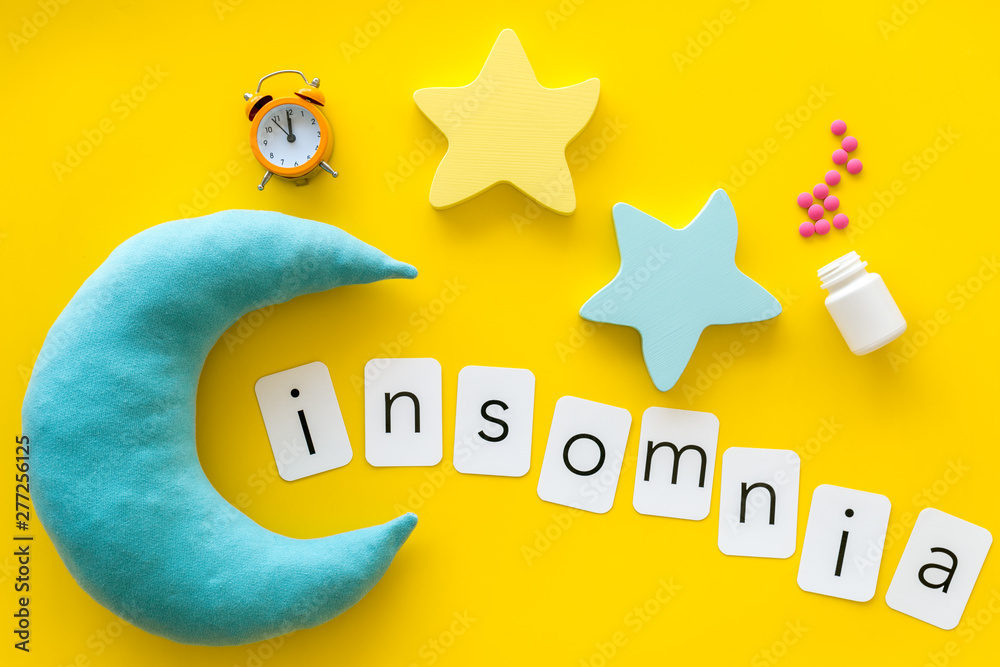 Insomnia word, pills, moon, srars, alarm for help yourself to fall asleep concept on yellow background top view