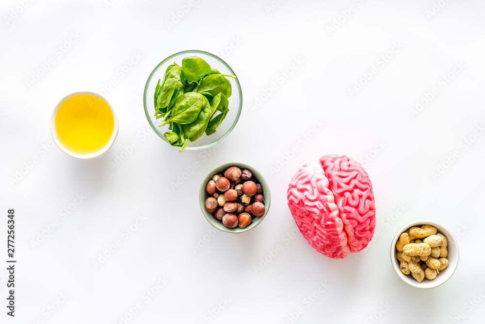 Proper nutrition for brain with nuts, spinage and oil stethoscope on white background top view