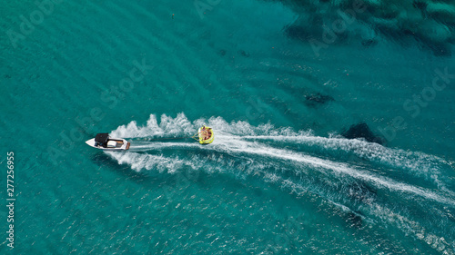 Aerial drone photo of extreme powerboat donut watersports crusing in high speed in famous sandy beach of Platy Gialos, Mykonos island, Cyclades, Greece