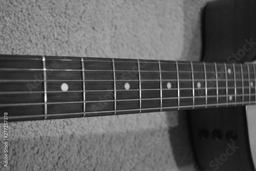 Up Close Photo of an Acoustic Guitar Neck with Six Strings and Dot Inlays