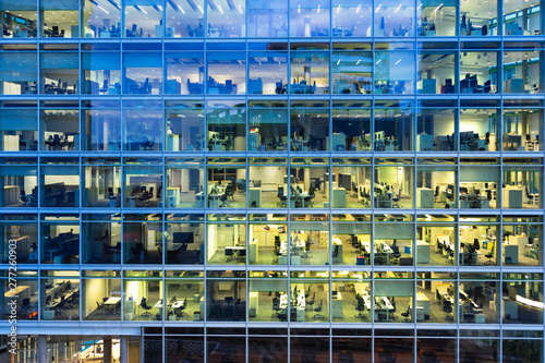 working late: illuminated office spaces in a modern building in the evening