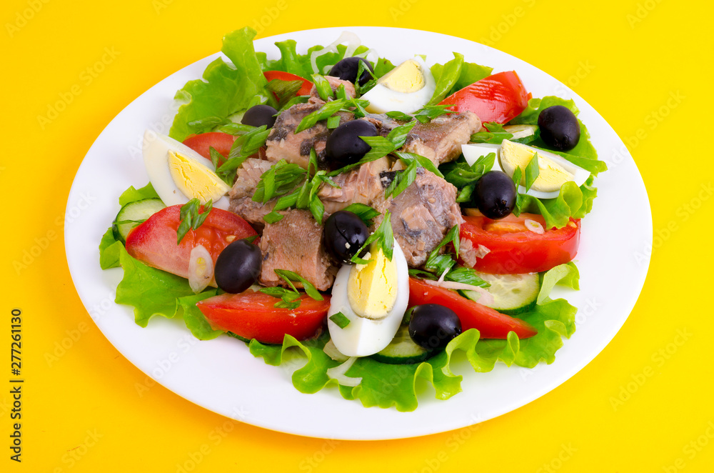 Salad of fresh vegetables, egg, canned fish and olives. 
