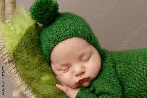 Sleeping newborn boy on a brown  background. 