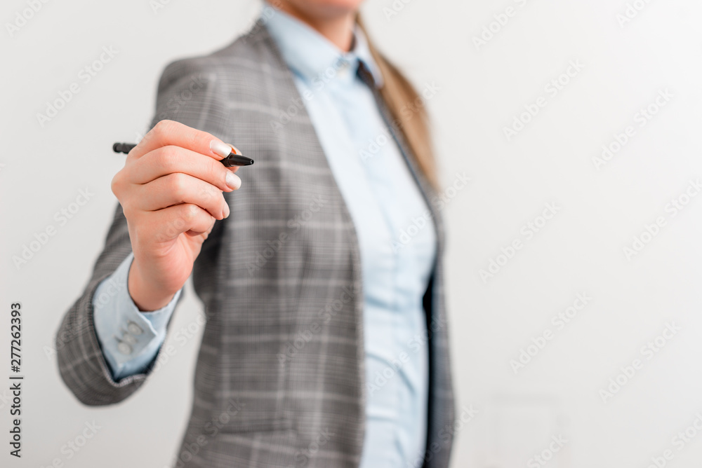 Business woman pointing in empty space with pen. Business woman pointing in empty space with pen.