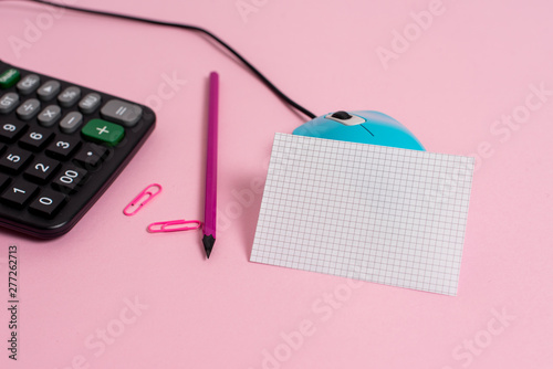 Wire mouse clips marker calculator squared paper sheet colored background photo