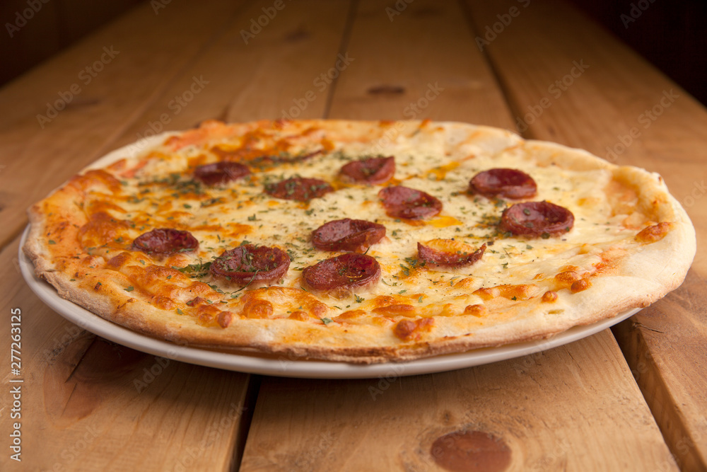 Delicious pepperoni pizza on a wooden table.
