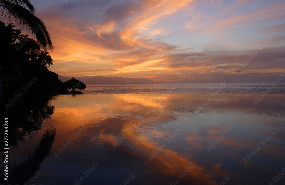 Sunset sky reflecting in infinity pool