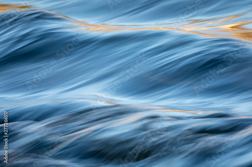 Water concept - river water flowing with light reflecting of its surface - long exposure shot photo