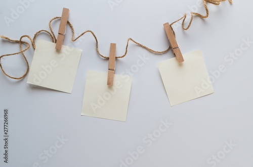 brown paper hung with clothspins on white background photo