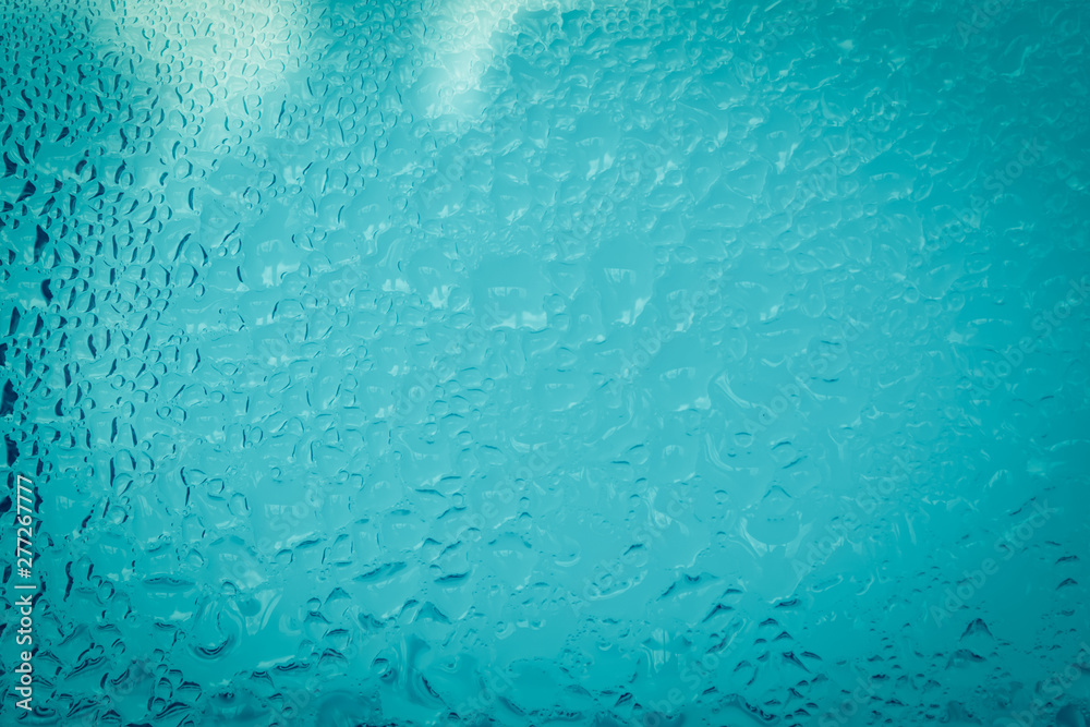 blue water drop on glass with backdrop blurred. dark tone blue water drop on glass with backdrop blurred. dark tone