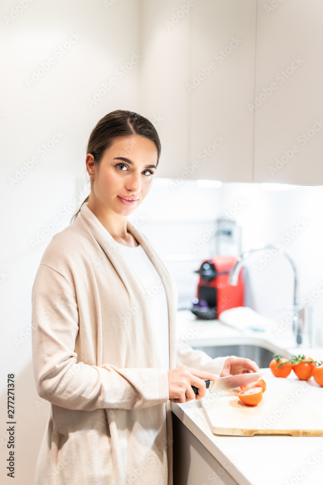 Young Woman Cooking in the kitchen. Young woman cut vegetables for salad. Young Woman Cooking in the kitchen. Young woman cut vegetables for salad.