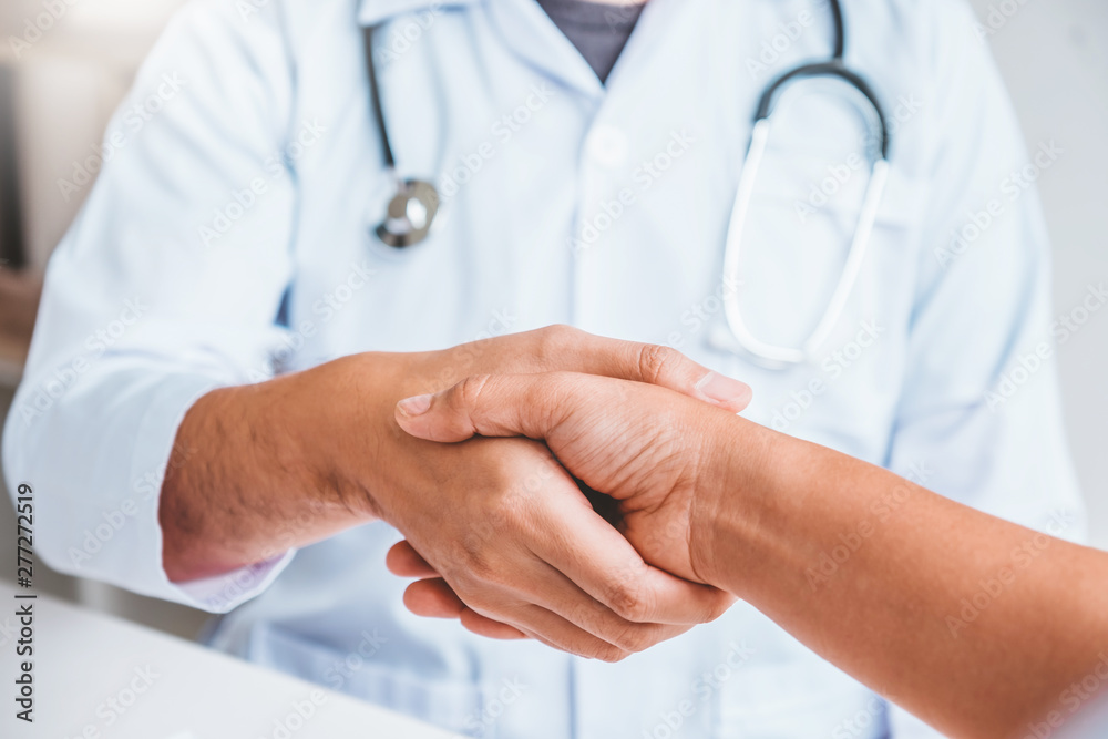 Doctor shaking hands with woman patients at hospital office Doctor shaking hands with woman patients at hospital office