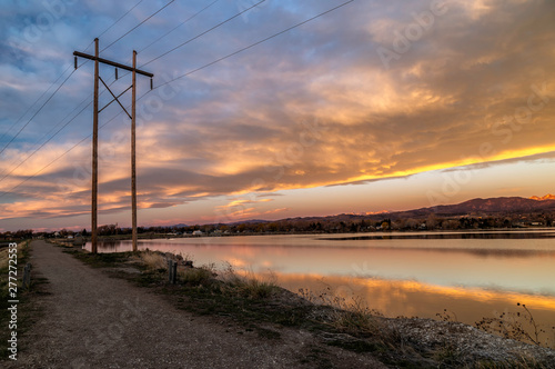 Electricity Poles at Sunrise with Colorado mountains and lake background