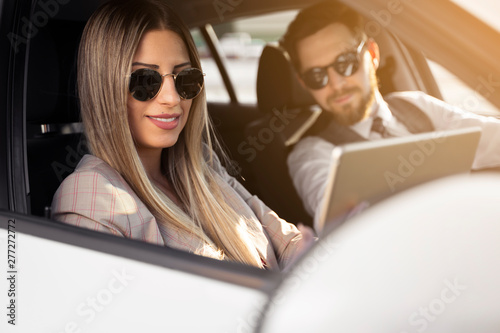 Elegant man and woman in a car , woman holding tablet  © phoenix021