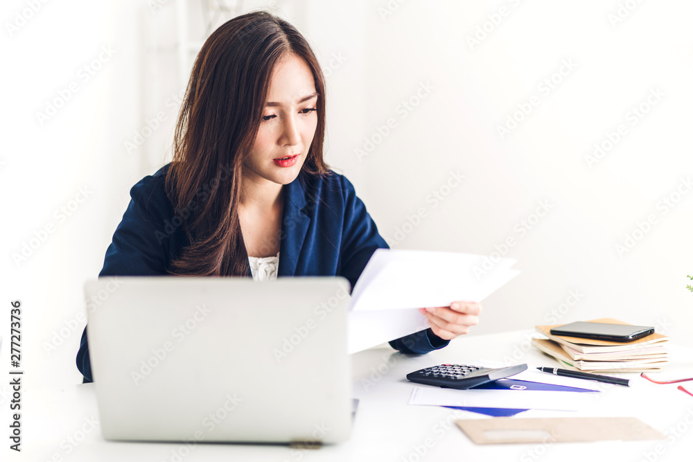 Businesswoman sitting and working with laptop computer.creative business people planning in her workstation at modern work loft Businesswoman sitting and working with laptop computer.creative business people planning in her workstation at modern work loft