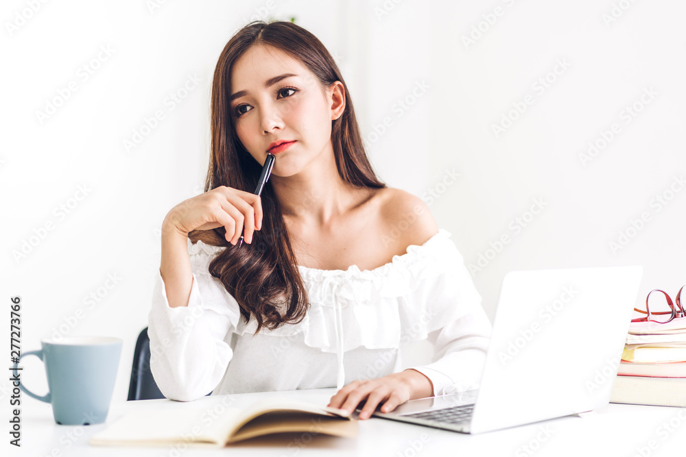 Girl student sitting and studying and learning online with laptop computer and reading a book before the exam at home.education concept Girl student sitting and studying and learning online with laptop computer and reading a book before the exam at home.education concept